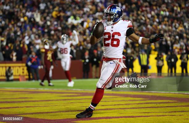 Saquon Barkley of the New York Giants scores a touchdown during the second quarter against the Washington Commanders at FedExField on December 18,...