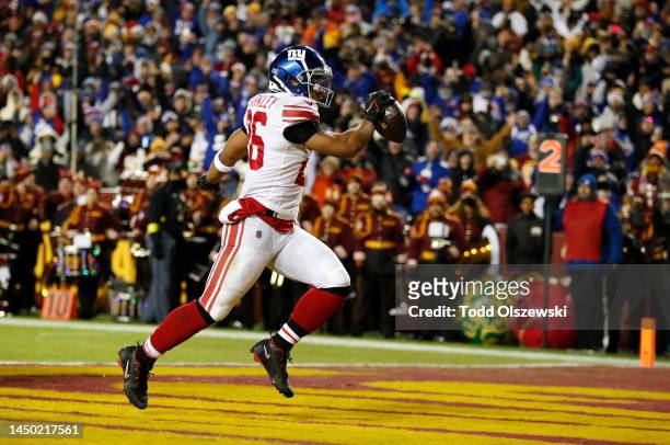 Saquon Barkley of the New York Giants scores a touchdown during the second quarter against the Washington Commanders at FedExField on December 18,...