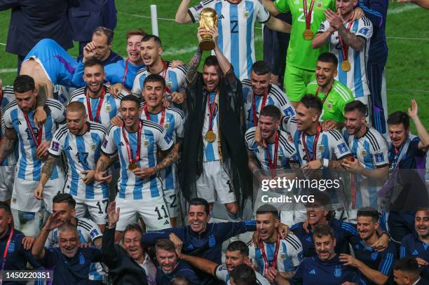 Lionel Messi of Argentina lifts the FIFA World Cup Trophy as he celebrates with team mates at the award ceremony following the FIFA World Cup Qatar...