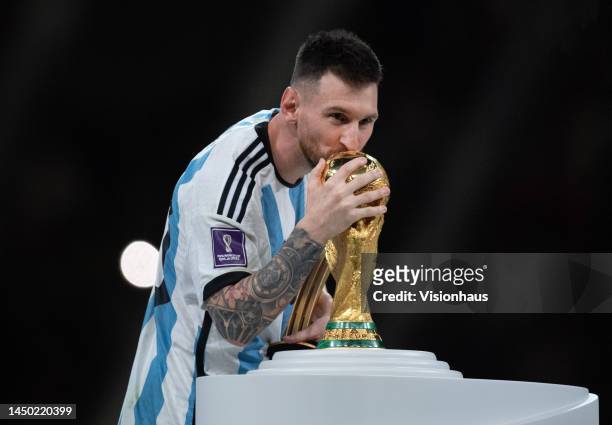 Lionel Messi of Argentina kisses the trophy after the FIFA World Cup Qatar 2022 Final match between Argentina and France at Lusail Stadium on...