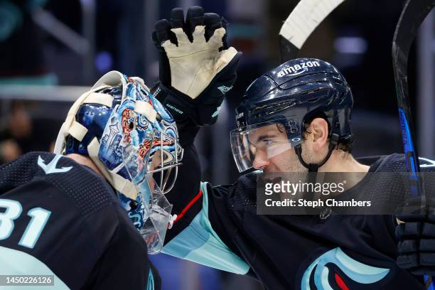 Philipp Grubauer and Justin Schultz of the Seattle Kraken celebrate their 3-2 win against the Winnipeg Jets at Climate Pledge Arena on December 18,...