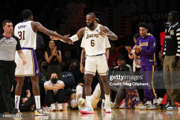 LeBron James of the Los Angeles Lakers reacts with Thomas Bryant in the second half against the Washington Wizards at Crypto.com Arena on December...