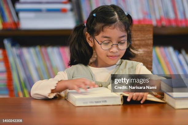 asian student girl is reading the book at library. - indonesian girl stock pictures, royalty-free photos & images