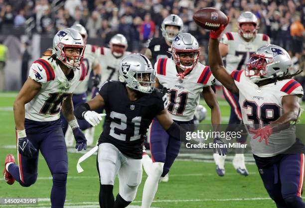 Running back Rhamondre Stevenson of the New England Patriots pitches the ball back to wide receiver Jakobi Meyers as cornerback Amik Robertson of the...