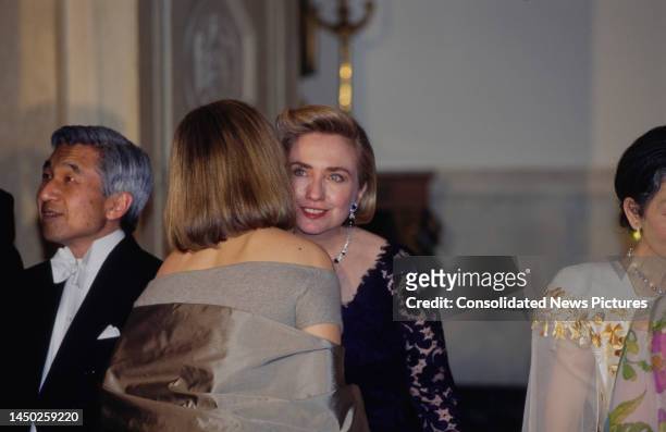 American singer and actress Barbra Streisand, wearing a pewter taffeta Donna Karan evening gown, greeted by American First Lady of the United States...