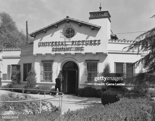 Man entering the Mission-style building housing the Universal Pictures Company Studios in Los Angeles, California, 1947. The studio logo is...