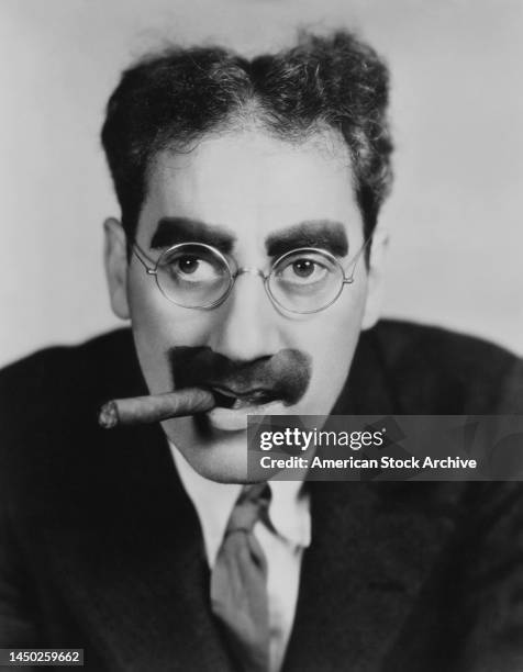 American comedian, actor, singer and vaudevillian Groucho Marx in a publicity portrait with his trademark spectacles, greasepaint moustache and...