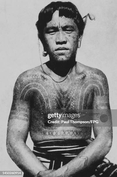 An Igorot man, with a heavily tattooed torso, Philippines, circa 1915. The Igorot people are the indigenous peoples of the Cordillera Mountain Range...