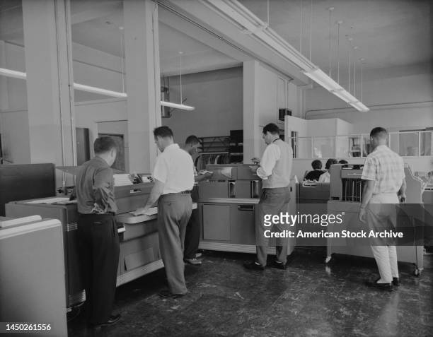 Men operating IBM Accounting Machines, tabulating equipment in an office, United States, circa 1955. Launched by IBM in the mid-20th century,...