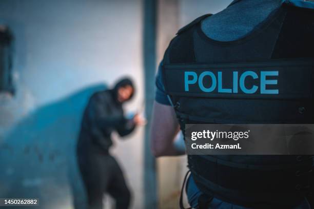 un policier attrape un criminel la nuit - malfaiteur photos et images de collection
