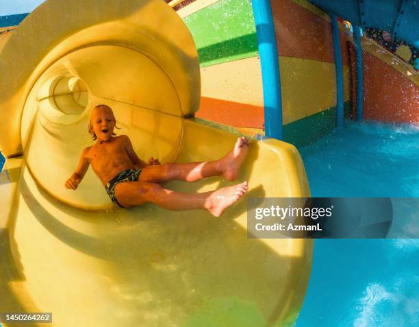 happy little kid enjoying the water slide - water flume stock pictures, royalty-free photos & images
