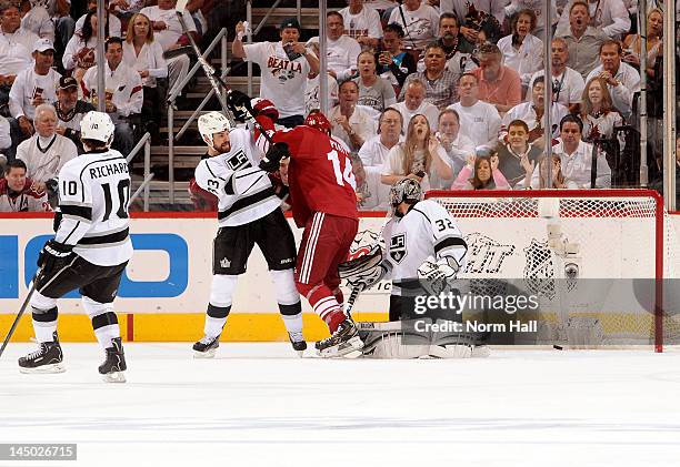 Willie Mitchell of the Los Angeles Kings tries to move Taylor Pyatt of the Phoenix Coyotes from the crease as teammate Jonathan Quick watches the...