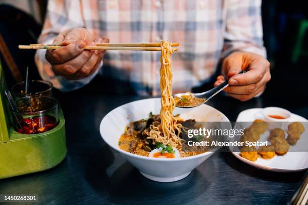 man eating thai noodle soup, close-up, bangkok, thailand - ramen noodles stock pictures, royalty-free photos & images