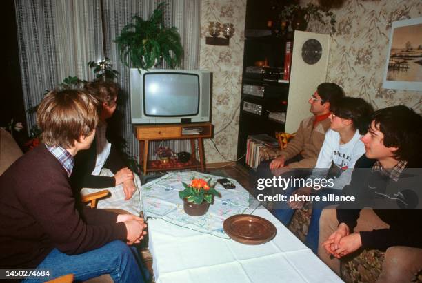 Familie Günter Becker aus Ludwigshafen, die an das Kabelprojekt angeschlossen ist, fernsehen gemeinsam in ihrem Wohnzimmer, aufgenommen 1984. Anfang...