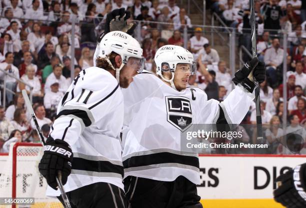 Anze Kopitar of the Los Angeles Kings celebrates with teammate Dustin Brown after Kopitar tips in a shorthanded goal in the first period on a shot by...