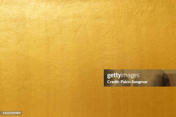 golden color with an old grunge wall concrete texture as a background. - golden pattern on walls fotografías e imágenes de stock
