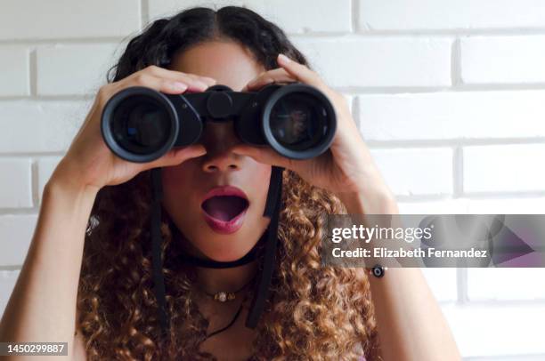 beautiful young woman looking through binoculars - finden suchen stock-fotos und bilder