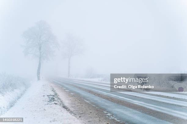 dangerous windy foggy road, forest around. winding of curvy spooky and misty road - chuva congelada imagens e fotografias de stock