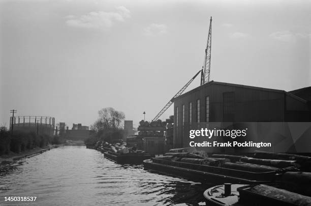 The towpath on the Grand Union Canal with industrial buildings and a gasometer visible in the background, England. Original Publication: Picture Post...