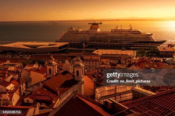 aerial view over the rooftops of lisbon and a cruise ship on tagus river - tagus river stock pictures, royalty-free photos & images