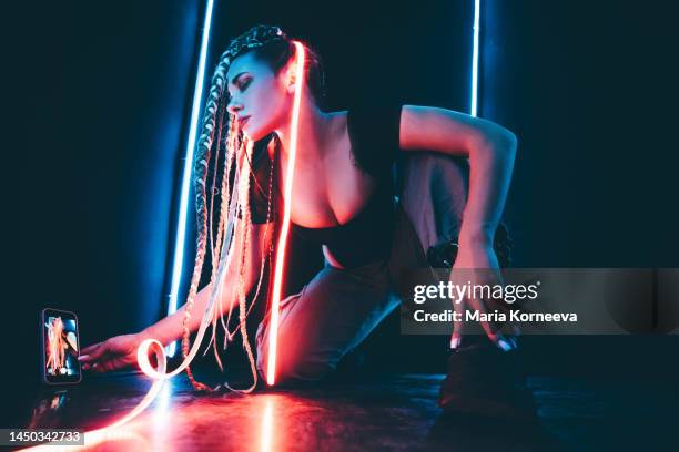 young woman live streaming on social media illuminated with neon lights. - big data white stock pictures, royalty-free photos & images