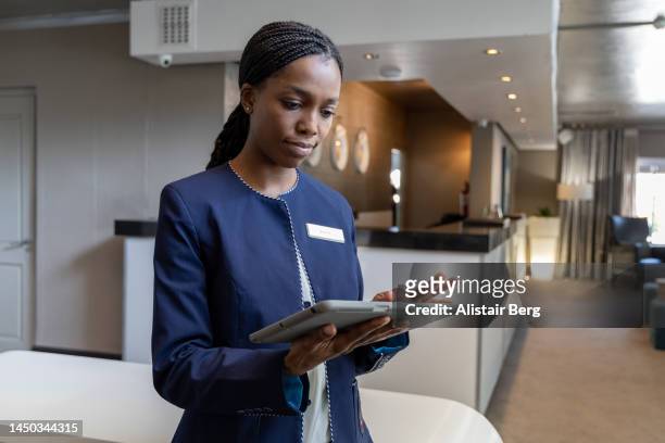 female hotel manager using digital tablet - hotel manager stockfoto's en -beelden
