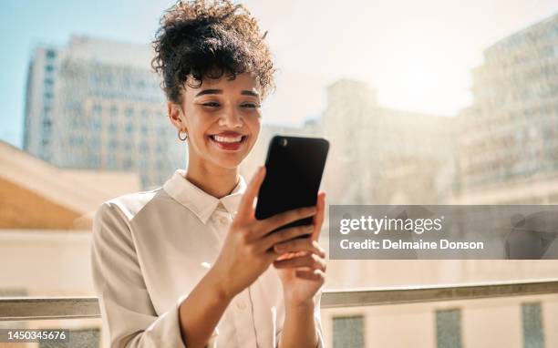 femme d’affaires brésilienne, téléphone près d’une fenêtre ou balcon de bureau dans le marketing numérique, la publicité ou la gestion d’horaire. designer souriant, heureux ou créatif sur la technologie de messagerie mobile ou l’application - palm photos et images de collection