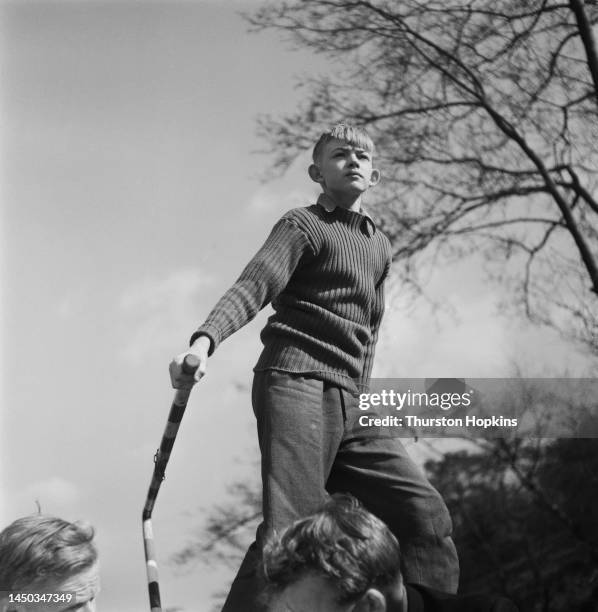 Boy operates the tiller of a narrow boat travelling on the Grand Union Canal, England. Original Publication: Picture Post - 7798 - The Scandal of our...