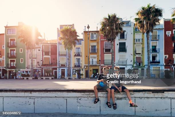 two teenagers sightseeing charming old town of villajoyosa - alicante street stock pictures, royalty-free photos & images
