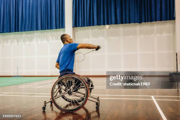 asian disabled badminton player in wheelchair playing badminton with friends. - badminton gloucestershire stock pictures, royalty-free photos & images