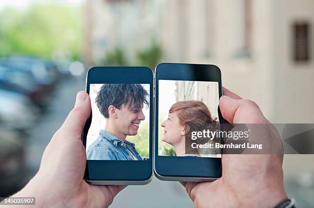 Young couple communicating via two smartphones