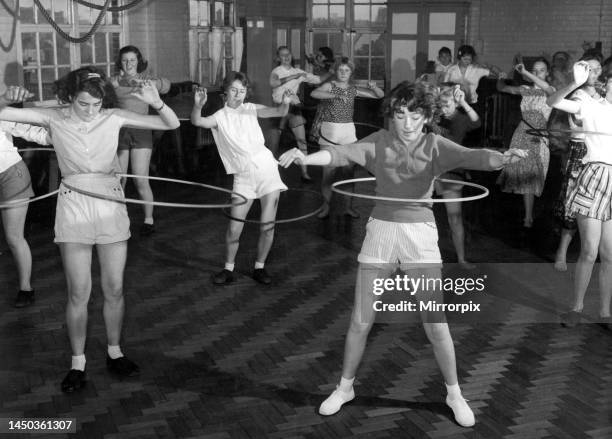 The Hula-hooping craze has caught on at the St. Paul's Way Secondary Central School at Bow, London during gym lessons. September 1958.