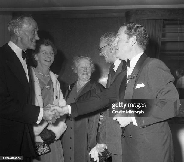 Actor Kenneth More shakes hands with Mr S. E. Daniels of Portsmouth, who was a survivor of the Titanic disaster, at the premiere of the film A Night...