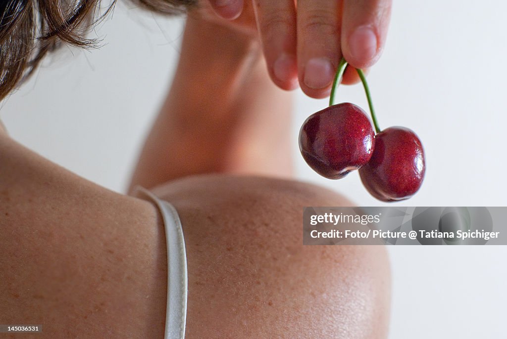 Human hand holding cherries