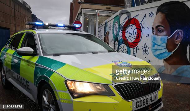 View of an emergency vehicle on contract to the NHS as it drives past artwork of a nurse and Doctor near the Bellvue entrance to the Royal Gwent...
