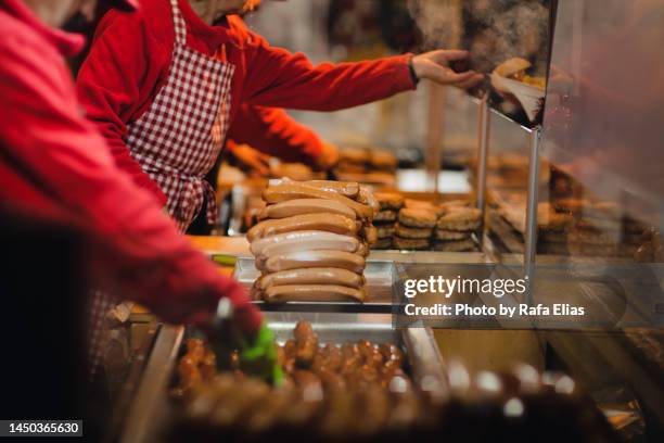 serving sausages hot dog at the christmas market - carne procesada fotografías e imágenes de stock