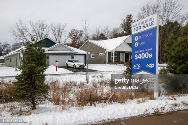 A row of suburban homes with a For Sale sign, illustrating rising inventory