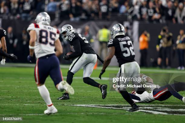Chandler Jones of the Las Vegas Raiders intercepts a backwards pass intended for Mac Jones of the New England Patriots and runs for a touchdown to...