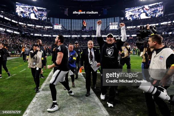 Derek Carr of the Las Vegas Raiders and head coach Josh McDaniels of the Las Vegas Raiders celebrate after defeating the New England Patriots during...