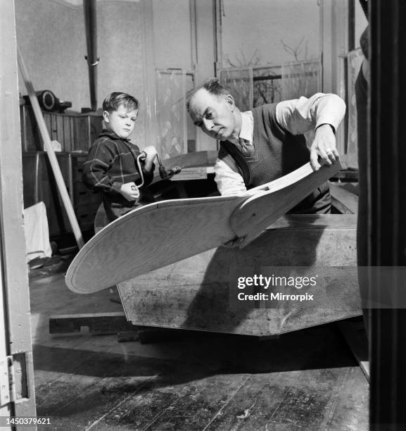 An elderly man in dining room with his grandson building the Royal yacht. December 1952.