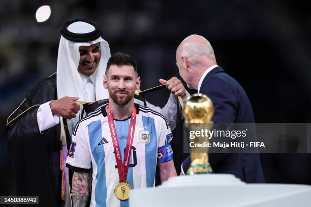 Lionel Messi of Argentina is presented with a traditional robe by Sheikh Tamim bin Hamad Al Thani, Emir of Qatar, during the awards ceremony after...