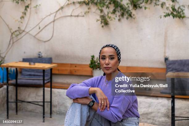 woman sitting in a cafe courtyard - middle east cool stock-fotos und bilder