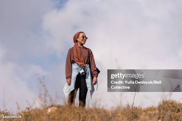 close-up view of a woman standing outside on a hill smiling - middle east cool stockfoto's en -beelden