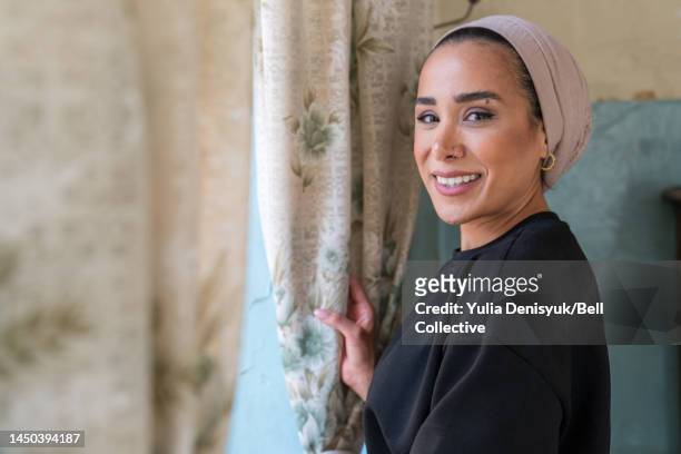 close-up view of a woman smiling by the window - middle east cool stock-fotos und bilder