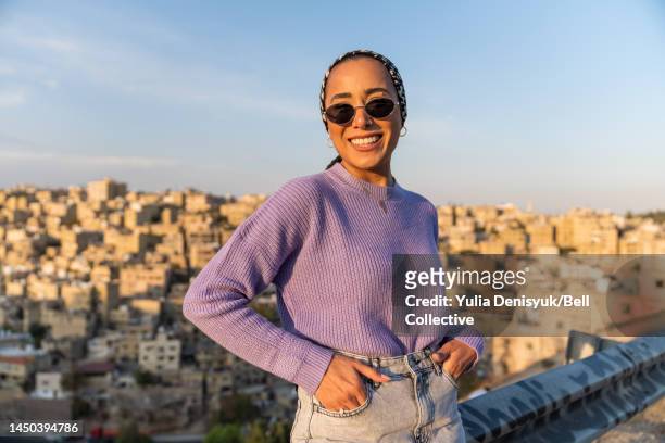 woman wearing sunglasses standing outside smiling - jordan or jordanian or the hashemite kingdom of jordan people or citizens ストックフォトと画像