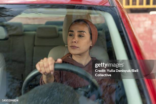 close-up view of a woman in a driver's seat of a vehicle - arab woman driving stockfoto's en -beelden