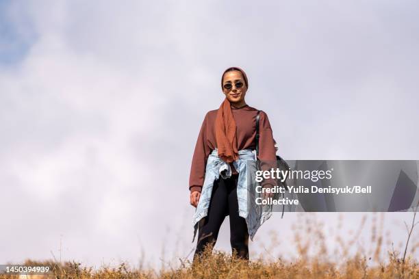 woman standing outside on a hill alone - middle east cool stock-fotos und bilder