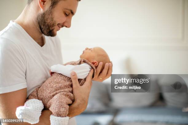 newborn baby sleeping in her father's arms - father and baby stock pictures, royalty-free photos & images