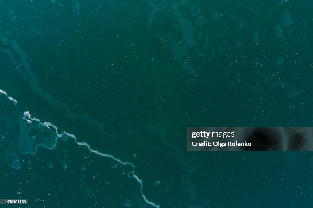 Sea water waves and ice foam on tides. Full frame
