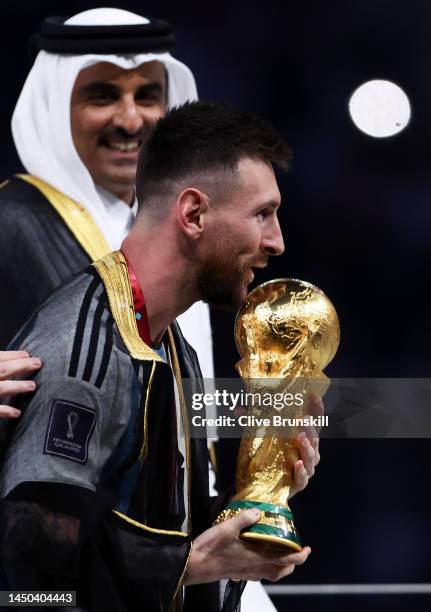 Lionel Messi of Argentina about to kiss the trophy he has just received from Sheikh Tamim bin Hamad Al Thani, Emir of Qatar before he lifts the FIFA...